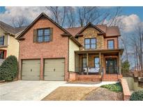 Two-story brick home with stone accents, two-car garage, and inviting front porch at 233 Yorkshire Ln, Villa Rica, GA 30180