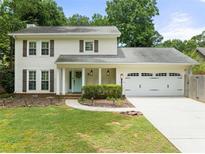 Charming two-story home features a manicured lawn, inviting entrance, and attached two-car garage at 6006 Lanier Heights Cir, Buford, GA 30518