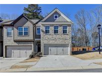 Two-story townhome with gray siding and a two-car garage at 2132 Arnage St, Stonecrest, GA 30058