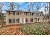 Two-story house with beige siding, black shutters, and landscaping at 2225 Mountain Creek Dr, Stone Mountain, GA 30087