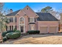 Brick house with two-car garage and manicured lawn at 820 Hillcrest Ln, Woodstock, GA 30189