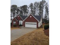 Brick ranch home with attached garage and landscaping at 202 Marston Dr, Suwanee, GA 30024