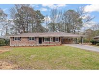 Charming brick ranch-style home featuring a well-manicured front yard and covered carport at 2643 Oswood Dr, Tucker, GA 30084
