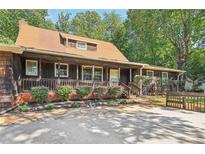 Ranch style home with wood siding, covered porch, and landscaped yard at 19 Roving Hills Cir, Cartersville, GA 30121