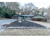 Ranch home with attached garage, landscaping, and a large yard at 2341 Amberbrook Sw Dr, Conyers, GA 30094