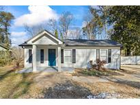 Charming white house with blue door, covered porch, and landscaped yard at 2860 Amelia Ave, Decatur, GA 30032