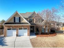 Two-story house with a brick and shingle exterior, two-car garage, and landscaping at 117 Sweet Basil Path, Loganville, GA 30052