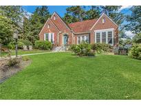 Charming brick home with a well-manicured lawn and beautiful landscaping and a clay tile roof at 1290 Pasadena Ne Ave, Atlanta, GA 30306