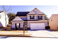 Two-story house with gray siding, white trim, and a two-car garage at 6636 Saint Jude Dr, Fairburn, GA 30213