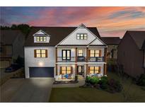 Two-story home with white brick, brown accents, and a welcoming front porch at 5060 Lloyd Ln, Cumming, GA 30040