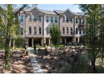 Brick townhomes with elegant entryways and manicured landscaping create an inviting curb appeal at 418 Townly, Alpharetta, GA 30009