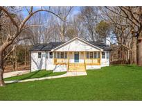 Charming home featuring a well-manicured lawn, inviting porch, and a freshly painted exterior at 1506 Country Ct, Auburn, GA 30011