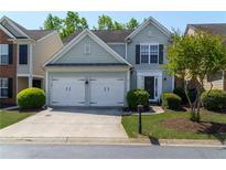 Charming two-story home featuring a two-car garage, lush landscaping, and a welcoming front entrance at 327 Balaban Cir, Woodstock, GA 30188