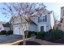 Two-story house with two car garage, manicured lawn, and neutral siding at 327 Balaban Cir, Woodstock, GA 30188