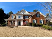Brick two-story house with a large front yard and a columned porch at 9801 Waters Edge Pointe, Villa Rica, GA 30180