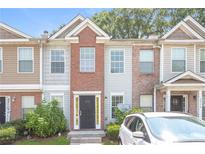 Brick front townhouse with a yellow door and a small yard at 2858 Vining Ridge Ter, Decatur, GA 30034