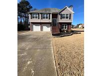 Two-story house with a three-car garage and landscaped yard at 2663 Barnwell Ct, Powder Springs, GA 30127