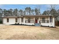 Charming ranch home with white brick exterior, covered porch, and landscaped yard at 3308 Wildwood Sw Dr, Marietta, GA 30060