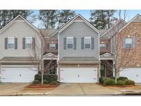 Three-unit townhome community; two-story homes with attached garages and landscaping at 6233 Thorncrest Dr, Tucker, GA 30084