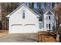 Two-story brick home with a two-car garage and mature trees at 3405 Doral Ln, Woodstock, GA 30189