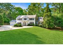 Charming two-story home with a manicured lawn and circular driveway surrounded by lush greenery at 3382 Habersham Rd, Atlanta, GA 30305