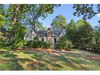 Charming home with lush landscaping, mature trees, and a stone chimney at 250 Lakeview Ne Ave, Atlanta, GA 30305