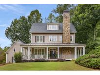 Two-story house with stone fireplace, wrap-around porch, and landscaped yard at 4130 Little Falls Dr, Cumming, GA 30041