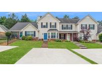 Two-story townhome with brick and siding exterior, landscaped lawn, and parking at 145 Gentle Breeze Ct, Temple, GA 30179