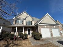 Charming two-story brick home featuring a well-manicured lawn and a two-car garage at 308 Jarrod Oaks Ct, Loganville, GA 30052