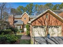 Brick front exterior of charming home with two-car garage and manicured landscaping at 11 Ivy Chase Ne, Atlanta, GA 30342