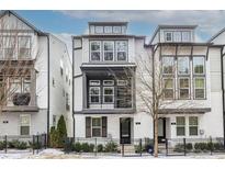 Modern three-story townhome with gray and white exterior, and a fenced front yard at 927 Katie Kerr Dr, Decatur, GA 30030