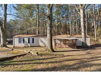 Inviting single-story home featuring a cozy front porch and a natural wooded setting at 5381 Groovers Landing Se Rd, Acworth, GA 30101