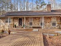 Charming stone-clad home with a spacious wooden front deck and inviting entrance at 5295 Ridge Rd, Douglasville, GA 30134
