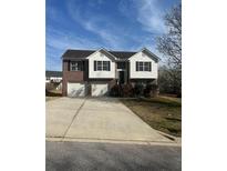 Charming two-story home featuring a brick facade, attached two-car garage, and well-maintained front yard at 8504 Browns Mill Trce, Lithonia, GA 30038