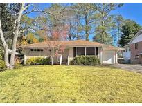 Ranch house with a spacious lawn, mature trees, and a detached garage at 2735 Spring Se Dr, Smyrna, GA 30080