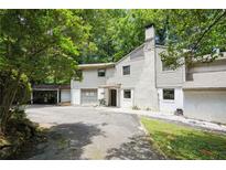 Ranch style home with a large driveway and mature trees at 2038 Clairmont Ne Ter, Atlanta, GA 30345