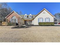 Brick and siding house with mature landscaping and a large yard at 4065 Delamar Dr, Cumming, GA 30041