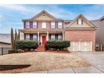 Charming two-story brick home with manicured landscaping, inviting front porch, and a two-car garage at 3920 Village Estates Ct, Cumming, GA 30040