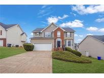 Two-story house with brick and siding exterior, attached garage, and landscaping at 415 Gresham Dr, Stockbridge, GA 30281