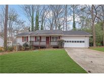 Ranch home with a carport and a grassy lawn at 4179 White Rd, Snellville, GA 30039