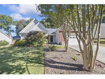 Ranch style home with mature landscaping and a two-car garage at 1855 Charleston Oak Cir, Lawrenceville, GA 30043