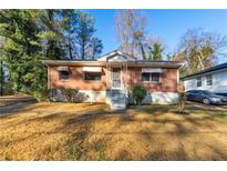 Brick ranch home with a landscaped yard and attached carport at 2257 Polar Rock Sw Ave, Atlanta, GA 30315