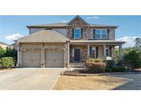 Brick two-story house with a two-car garage and landscaping at 5615 Cowles Cir, Suwanee, GA 30024