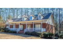 Brick ranch house with a wraparound porch, dormer windows, and landscaping at 95 Twin Lakes Dr, Carrollton, GA 30116