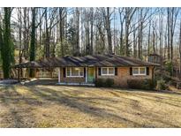 Ranch house with carport and large backyard nestled in a wooded area at 6467 Joanna St, Lithia Springs, GA 30122