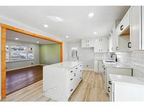 Bright kitchen features an island with white cabinets, countertops, and stainless steel appliances at 6467 Joanna St, Lithia Springs, GA 30122