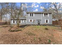 Charming gray two-story home with white shutters, complemented by natural landscaping at 3570 Knoll Crest Trl, Buford, GA 30519