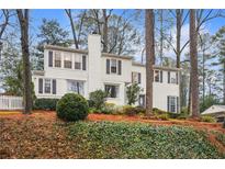 White two-story house with mature trees and landscaping at 1992 Walthall Nw Dr, Atlanta, GA 30318