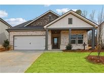 Charming single-story home with brick and stone accents, a well-manicured lawn, and attached two car garage at 3921 Brushy St, Powder Springs, GA 30127