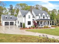 Stunning farmhouse exterior with a charming front porch and landscaped lawn at 103 Arbor Oaks Dr, Canton, GA 30115